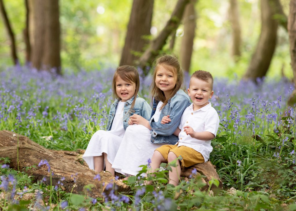 kids sitting in the bluebell wood