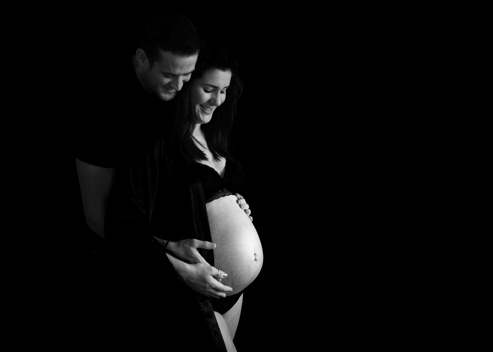man and women hugging baby bump during a photoshoot in Chatham