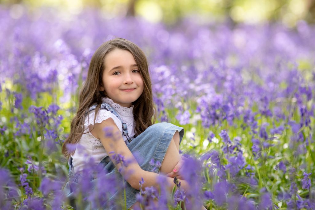 outdoor family photoshoot girl sitting in bluebell wood in Kent