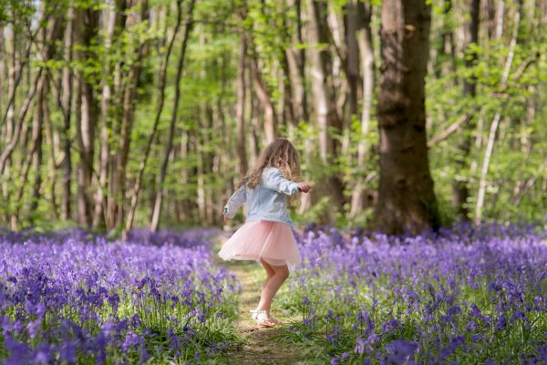 girl dancing in bluebell wood during a photoshoot in Kent