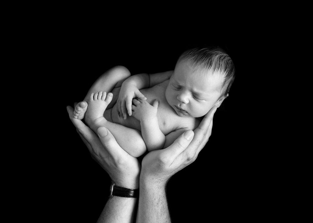 baby boy being held in dads hands during a photoshoot in Chatham