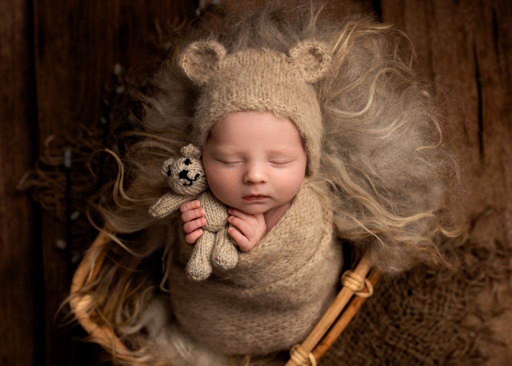 baby boy in bear bonnet hugging a teddy during a photoshoot in Chatham