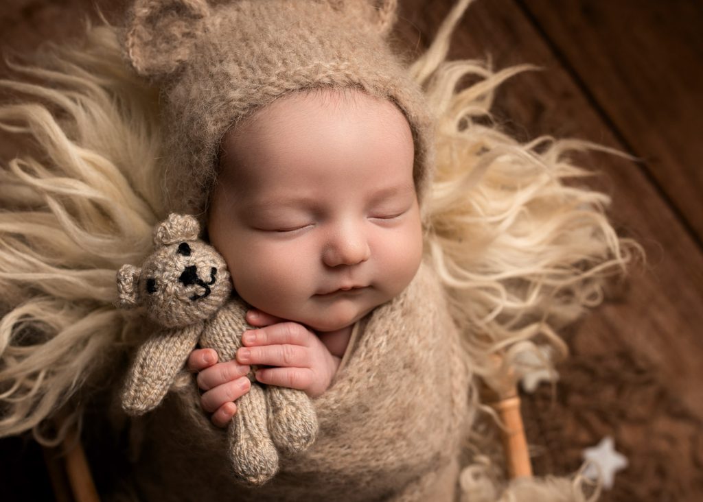baby boy cuddling a teddy during a photography session in Kent
