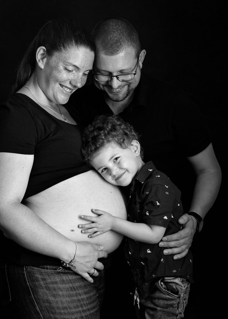 family and boy cuddling baby bump during a photoshoot in Kent