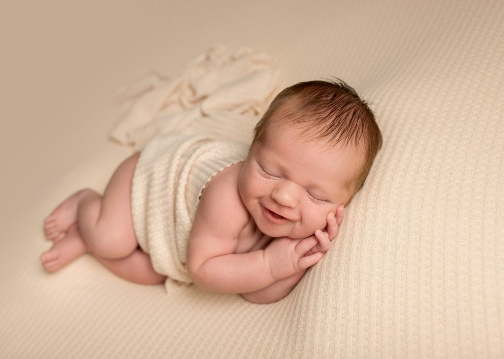 baby smiling during a newborn photoshoot in Chatham