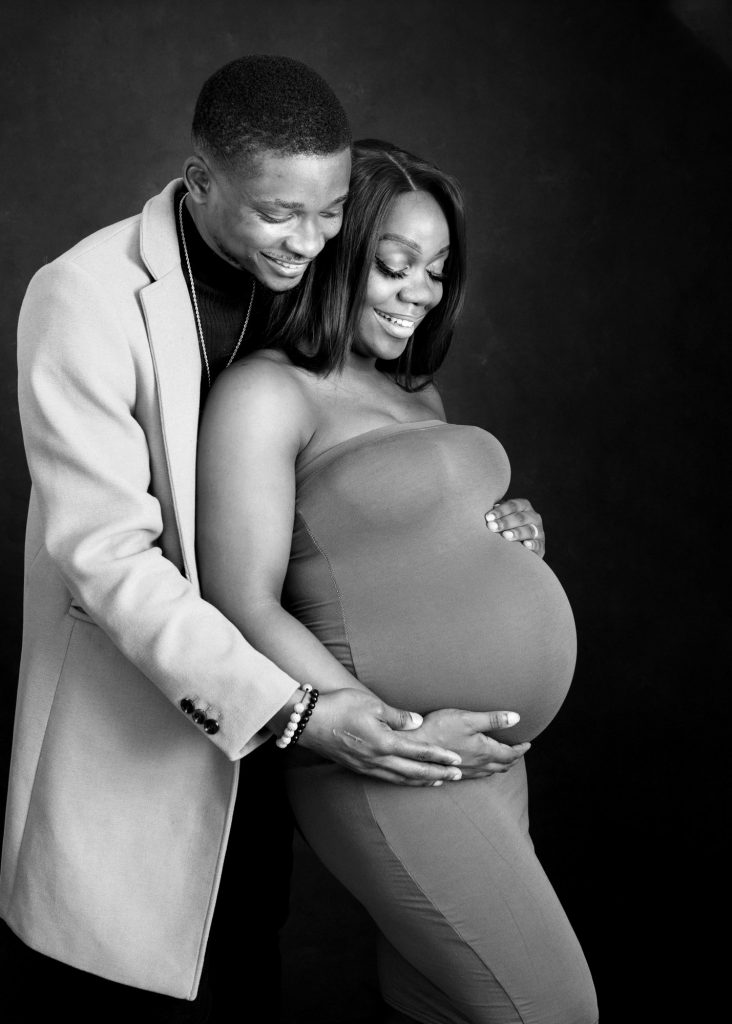 mum and dad to be cradling baby bump during maternity photoshoot in Kent